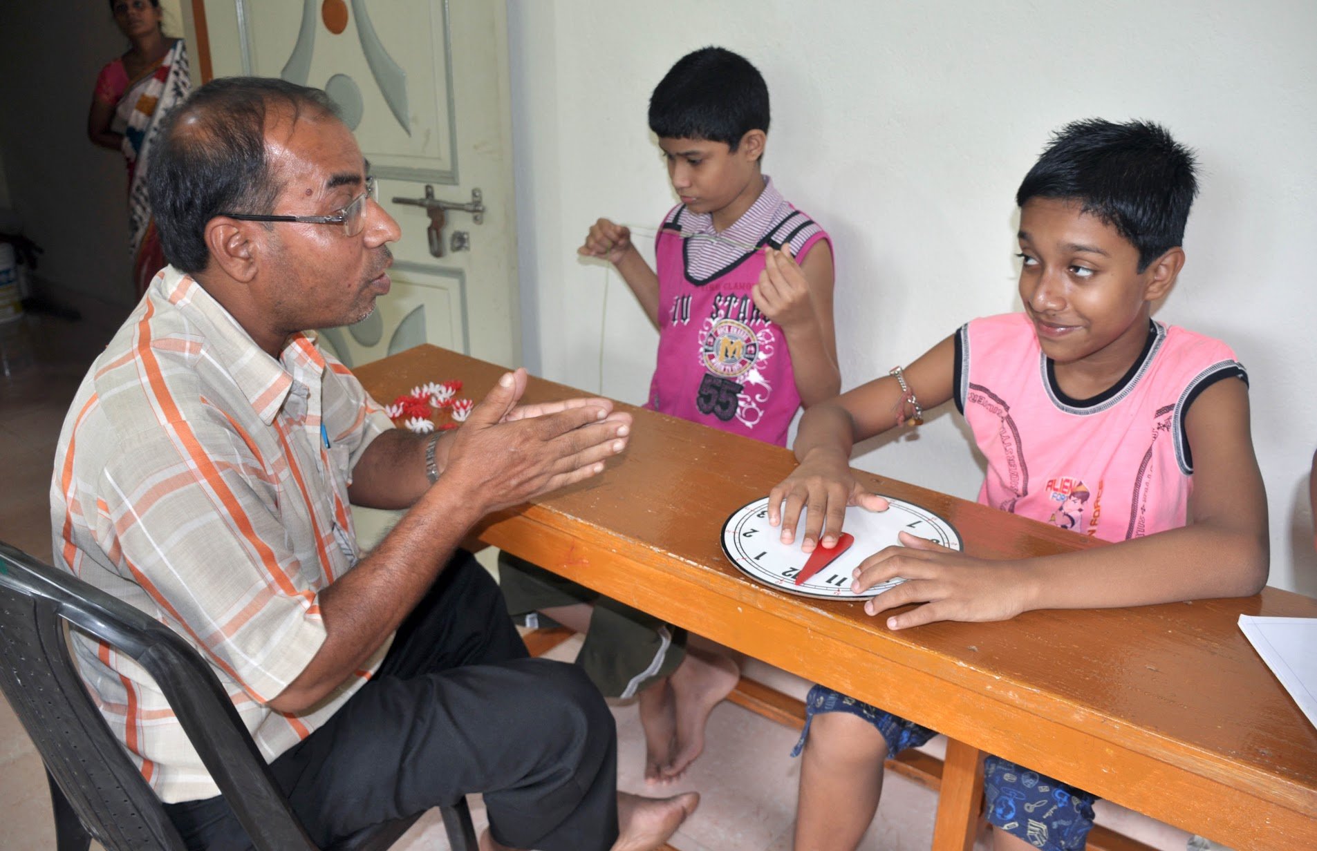 Children working on fine motor skills with teacher at KLI
